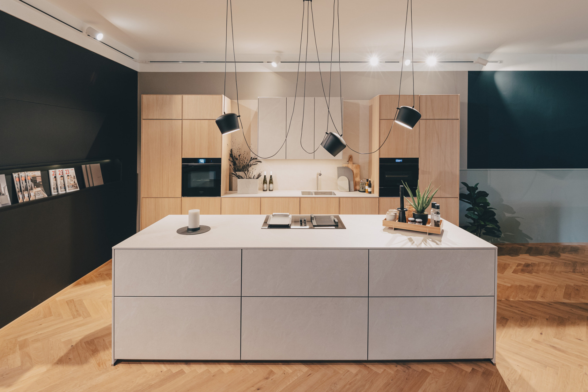 next125 küche mit hochschränken in heller eiche, KOCHINSEL in keramik und pendelleuchten im SHOWROOM in Weinheim