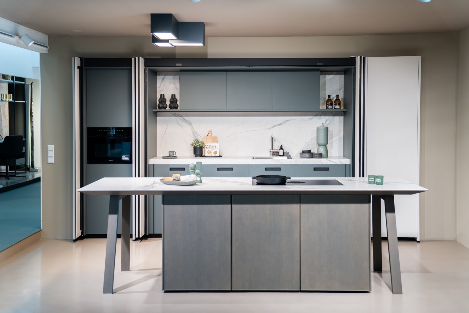next125 küche mit KOCHINSEL auf schrägen beinen und rückwand in marmoroptik im SHOWROOM in Weinheim