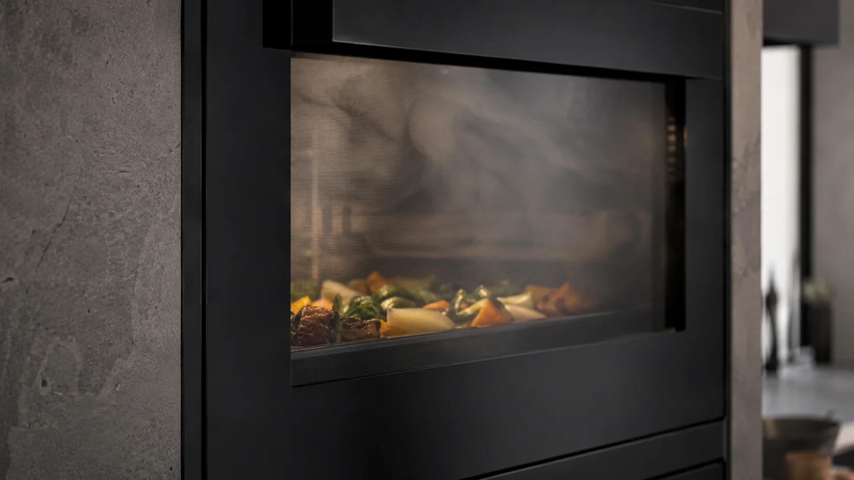 backofen mit dampfgarer im detail mit dampf und gemüse hinter dem glas