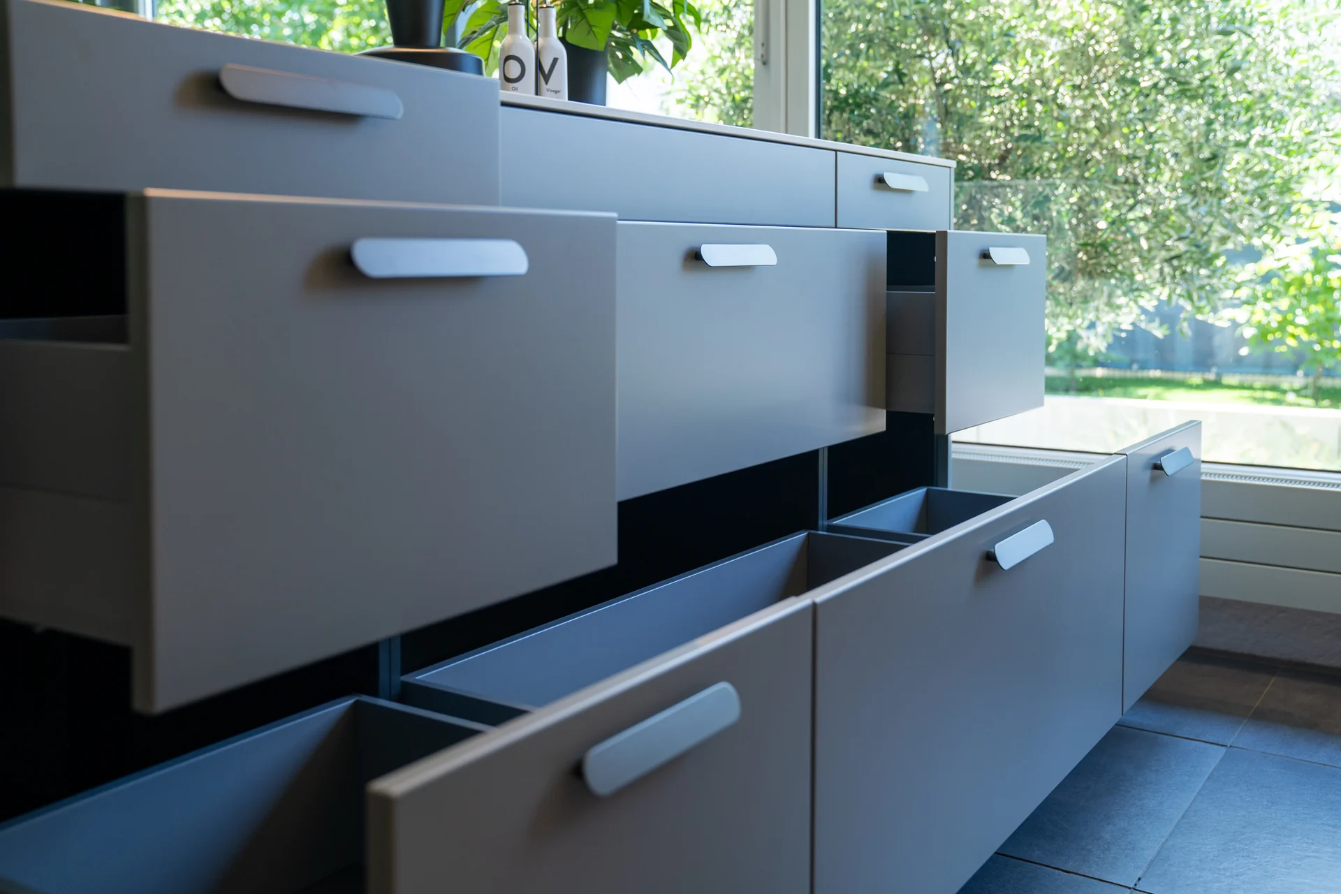 Geöffnete schubladen der SCHÜLLER küche in terragrau in KOJE 8 im SHOWROOM in Weinheim
