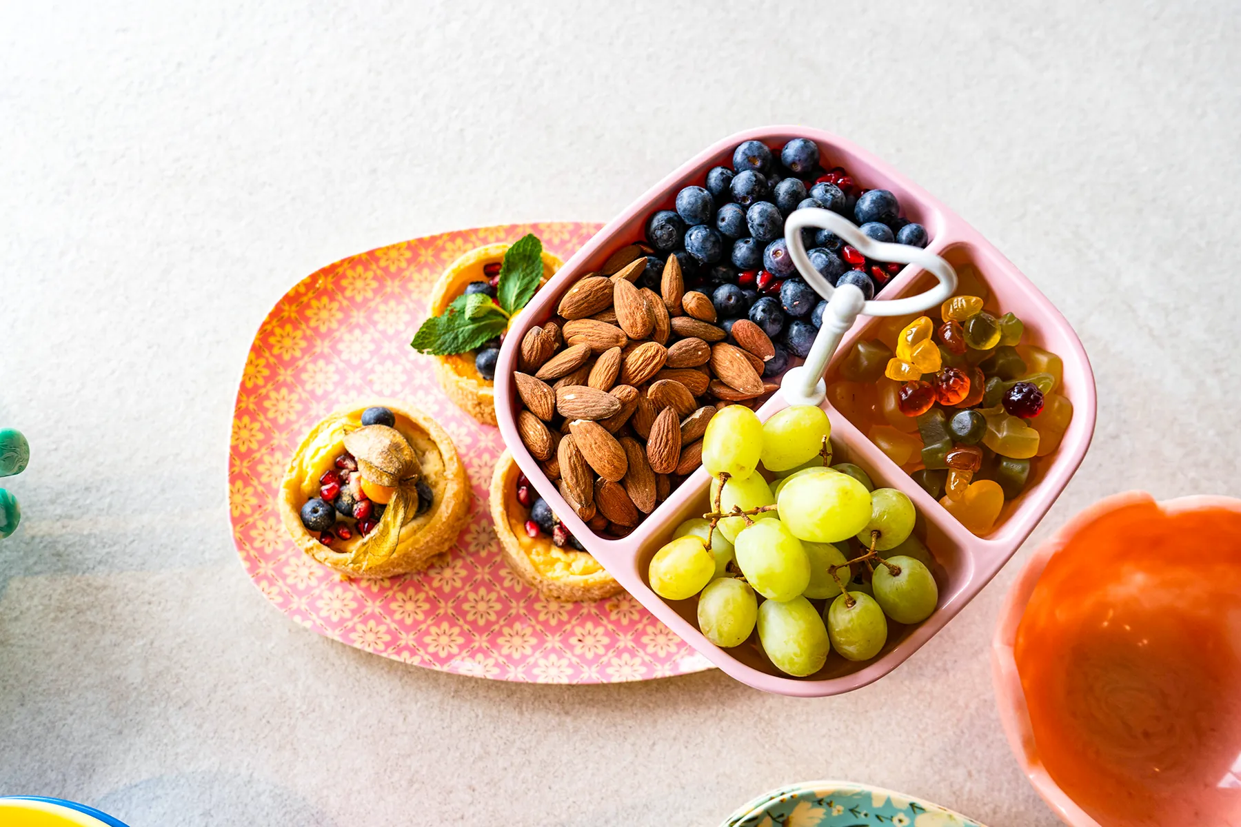 Etagere mit obst und nüssen auf gemustertem teller